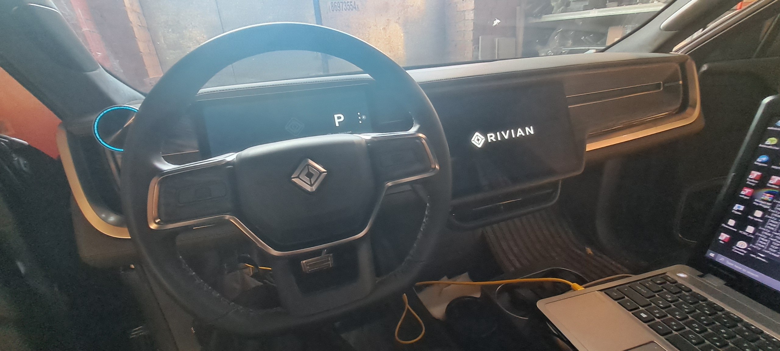 Kierownica, ekran centralny i laptop we wnętrzu Riviana